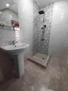 uma casa de banho com um lavatório e um chuveiro em Davit batoni Guest house em Mtskheta