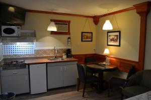 uma cozinha com um lavatório e uma mesa em North Star Motel em Kimberley