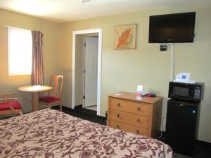 a hotel room with a bed and a flat screen tv at Knights Inn London Ontario in London