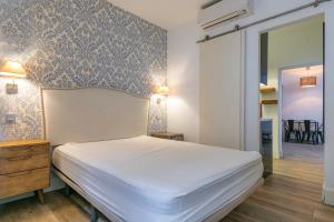 HOMEABOUT DIEGO DE LEÓN Apartment I في مدريد: غرفة نوم بسرير ابيض وجدار ازرق