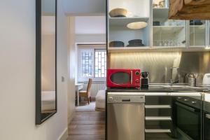 HOMEABOUT DIEGO DE LEÓN Apartment I في مدريد: مطبخ مع ميكروويف احمر على كونتر