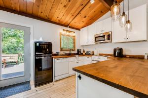 a kitchen with white cabinets and a wooden ceiling at Lily Haus in Idyllwild +11 photos