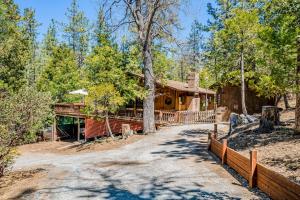 a house in the woods with a fence around it at Lily Haus in Idyllwild
