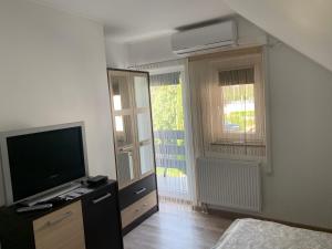 salon z telewizorem i sypialnia w obiekcie Komo Apartment w mieście Bük