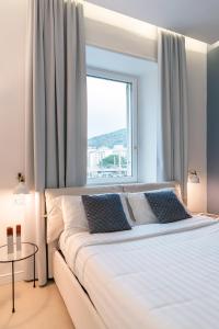 a bedroom with a large white bed with a window at Starhost - PETIT B&B in Salerno