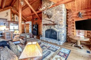 a living room with a stone fireplace in a log cabin at Two Bears in Franklin