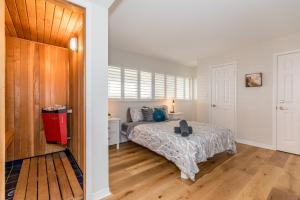 ein Schlafzimmer mit einem Bett in einem Zimmer mit Holzböden in der Unterkunft Stunning Townhouse - 3 BDRM Blue Mountain Village Sauna! in Blue Mountains