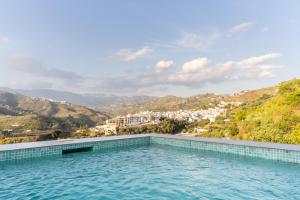 a swimming pool with a view of a city at Finca Jacinto in Sayalonga