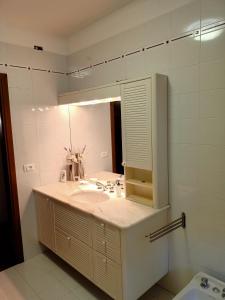 een badkamer met een wastafel en een spiegel bij Villa Luna in San Floriano del Cóllio