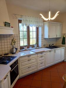 een keuken met witte kasten en een fornuis met oven bij Villa Luna in San Floriano del Cóllio