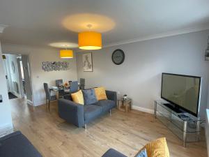 a living room with a couch and a television at The Shires in Nuneaton