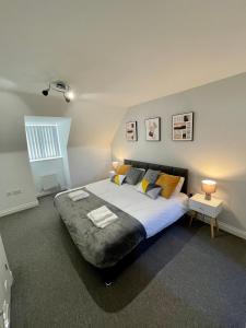 1 dormitorio con 1 cama grande, 2 mesas y 2 lámparas en The Shires en Nuneaton