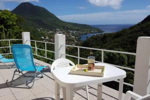 a white table and chairs on a balcony with a view at BEL APPARTEMENT T2 LUMINEUX in Les Anses-dʼArlets