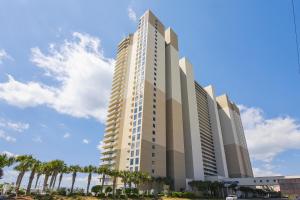 ein hohes Gebäude mit Palmen davor in der Unterkunft Celadon Beach Resort #1104 by Book That Condo in Panama City Beach