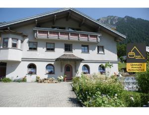 - un grand bâtiment blanc avec un panneau devant dans l'établissement Landhaus Luzia, à Wald am Arlberg