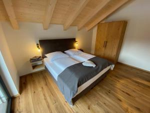 ein Schlafzimmer mit einem großen Bett und Holzboden in der Unterkunft Our's Living in Hollersbach im Pinzgau