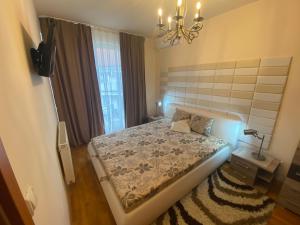 Schlafzimmer mit einem Bett und einem Kronleuchter in der Unterkunft Thermal Lux apartman in Hajdúszoboszló
