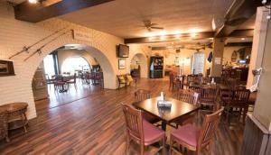 a restaurant with tables and chairs in a room at The Gananoque Inn in Gananoque