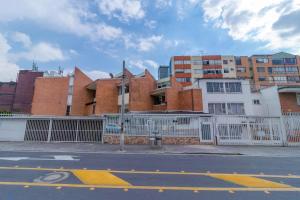 un edificio con una valla blanca al lado de una calle en Casa Hotel Quinta Real, en Bogotá