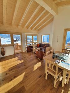 a living room with a table and a couch at Alpen-Park Dachwohnung Ost in Riederalp