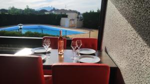 - une table avec une bouteille de vin et des verres dans l'établissement Le Vénusia du CAP - Clim, stationnement, ménage et linge fournis, au Cap d'Agde