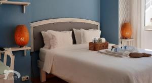 a bedroom with a white bed with blue walls at Infante Guesthouse in Lagos