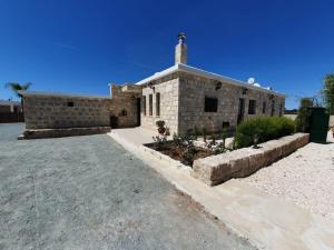 una chiesa di pietra con una croce sopra. di Villa Yermanina a Yeroskipou