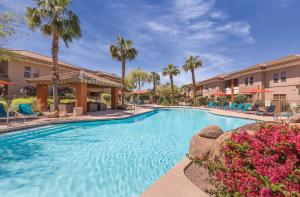 a swimming pool at a resort with palm trees at WorldMark Scottsdale in Scottsdale