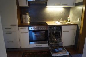 a kitchen with a stove and a sink at Landhaus Luzia in Wald am Arlberg