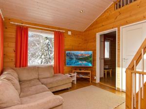 a living room with a couch and a large window at Holiday Home Hallan paroni a paritalo by Interhome in Hyrynsalmi