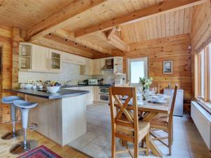 Little PetherickにあるChalet Peroniの木製の天井、テーブルと椅子付きのキッチンが備わります。