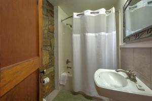a bathroom with a sink and a shower curtain at Linville Falls Lodge & Cottages in Linville Falls