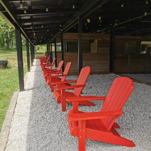 una fila de sillas rojas sentadas en una fila en Happy Goat Retreat en Willis