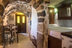 a room with a bed in a stone wall at Palaiokastro Traditional House in Mandrakion