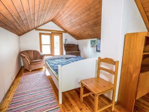 ein kleines Schlafzimmer mit einem Bett und einem Stuhl in der Unterkunft Holiday Home Kesämäki by Interhome in Hiukkajoki + 11 Fotos