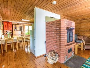 ein Wohnzimmer mit einem gemauerten Kamin und einem Esszimmer in der Unterkunft Holiday Home Kesämäki by Interhome in Hiukkajoki