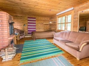 ein Wohnzimmer mit Sofa und Kamin in der Unterkunft Holiday Home Kesämäki by Interhome in Hiukkajoki
