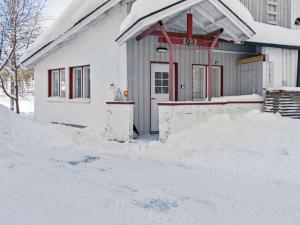 a house with a pile of snow in front of it at Holiday Home Hallantytär b3 paritalo by Interhome in Hyrynsalmi
