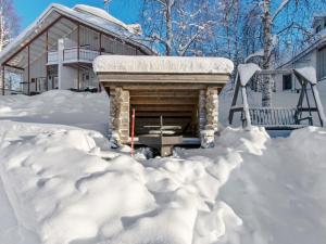 a house covered in snow with a fireplace at Holiday Home Hallantytär b3 paritalo by Interhome in Hyrynsalmi
