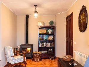 a living room with a fireplace and a book shelf at Casa Rural Ablanos de Aymar in Loroñe