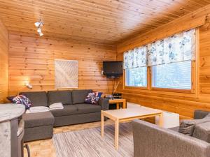 ein Wohnzimmer mit Sofa und Fernseher in der Unterkunft Holiday Home Paljakan pirtit a1 by Interhome in Kotila