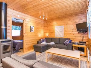 ein Wohnzimmer mit Sofa und Fernseher in der Unterkunft Holiday Home Paljakan pirtit a1 by Interhome in Kotila