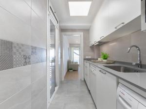 a kitchen with white cabinets and a sink at Apartment Reus Mediterraneo by Interhome in Vilafortuny