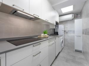 a white kitchen with a sink and a refrigerator at Apartment Reus Mediterraneo by Interhome in Vilafortuny +32 photos
