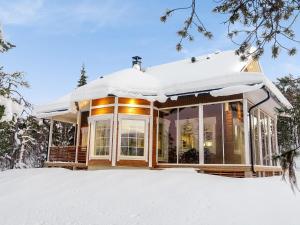 a house covered in snow in the snow at Holiday Home Villa tunturisopuli by Interhome in Raattama