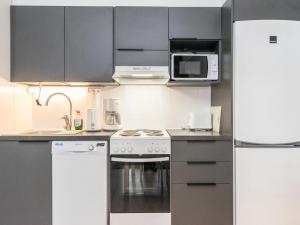 eine Küche mit Herd und Mikrowelle in der Unterkunft Holiday Home Skivillas paljakka 1- - 3 bedroom by Interhome in Kotila + 9 Fotos