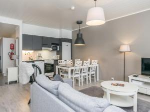 ein Wohnzimmer mit Couch und Tisch und eine Küche in der Unterkunft Holiday Home Skivillas paljakka 1- - 3 bedroom by Interhome in Kotila