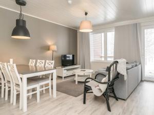 a dining room and living room with a table and chairs at Holiday Home Skivillas paljakka 1- - 3 bedroom by Interhome in Kotila
