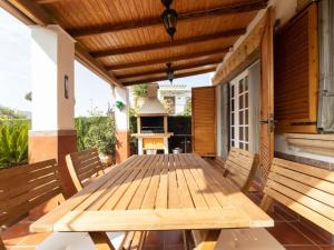 uma mesa de madeira no alpendre de uma casa em Holiday Home Villa Jardin by Interhome em Vilafortuny