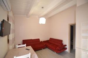 uma sala de estar com duas cadeiras vermelhas e uma mesa em Terrazza sul mare em Porto SantʼElpidio